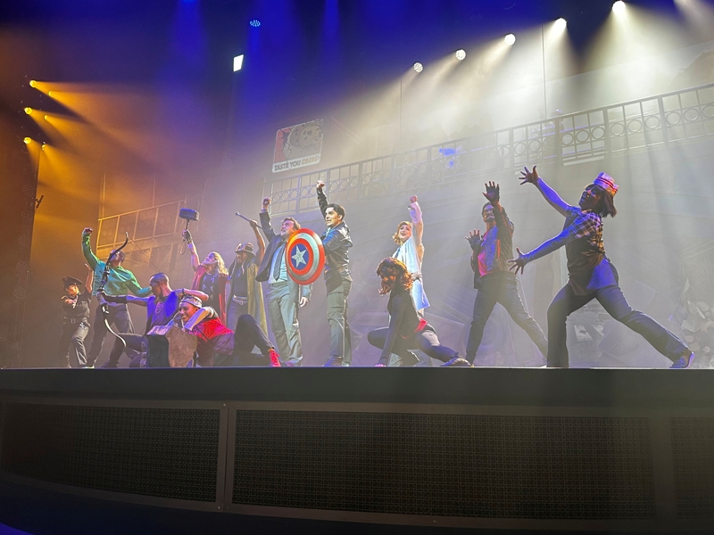 Performers pose after a musical number during Rogers: The Musical