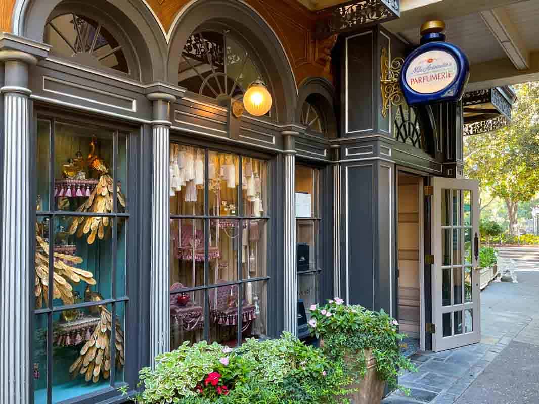 The front of a store with a lot of potted plants in New Orleans Square at Disneyland