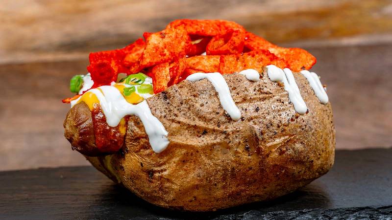 A potato stuffed with chili and cheese and a hot dog