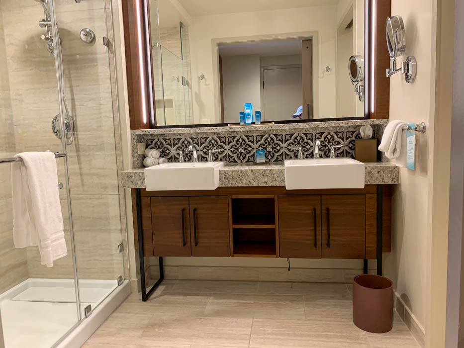 A bathroom with two sinks and a shower stall.