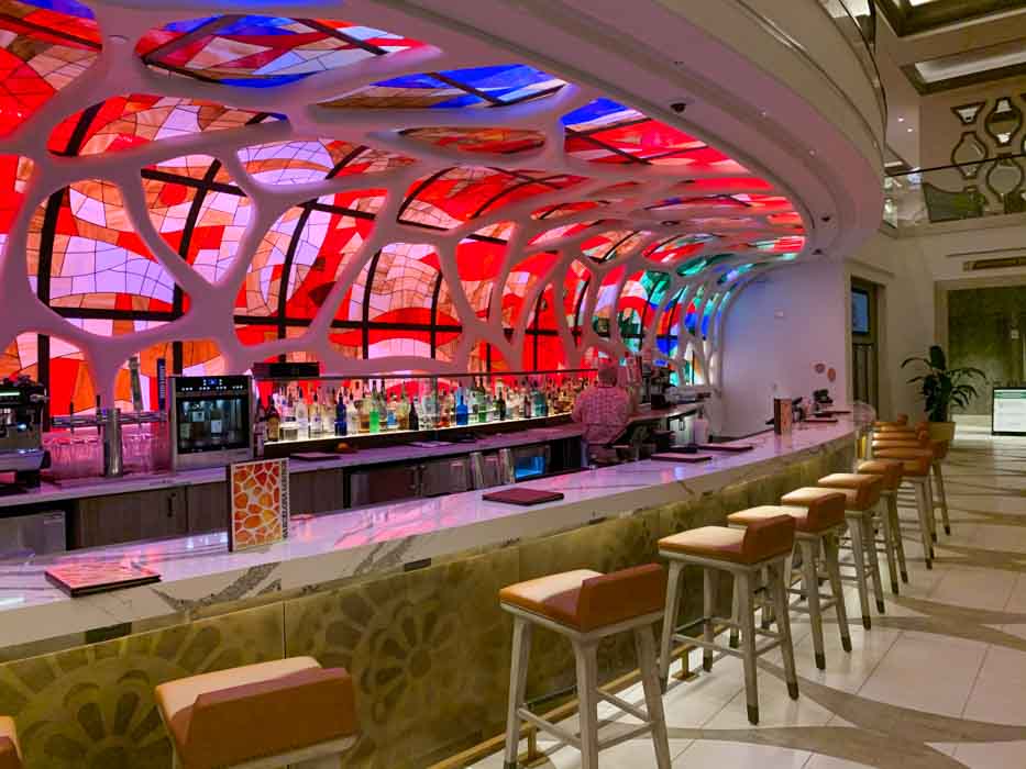 Barcelona bar in Gran Destino tower with a colorful ceiling and white barstools