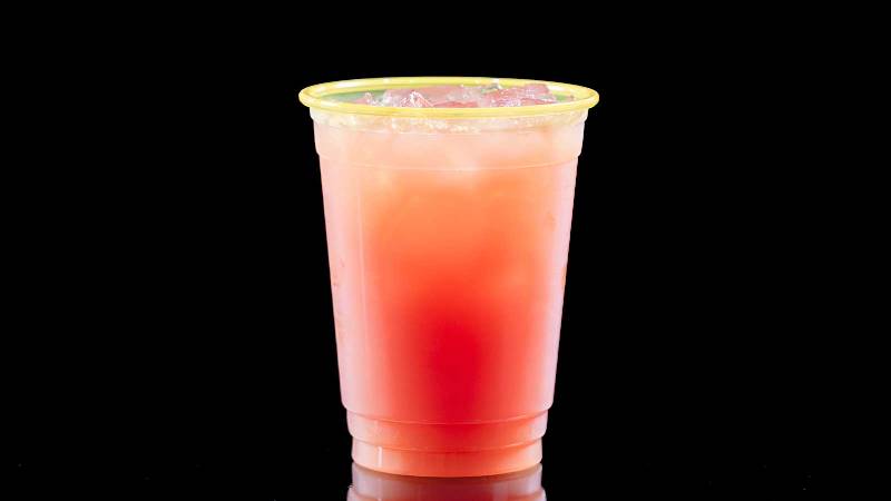 A pink drink with a yellow rim on a black background.