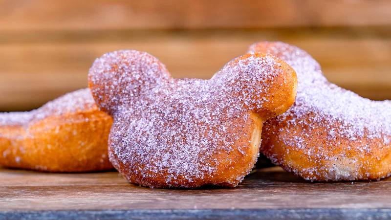 Mickey mouse shaped beignets on a wooden table